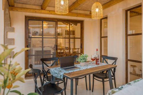 a dining room with a table with a laptop on it at Disegno Villa - Rooftop Pool in Kolymvari