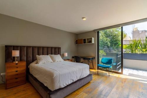 een slaapkamer met een bed en een groot raam bij Casa Mezcal. Arte, diseño y amenidades unicas. in Mexico-Stad