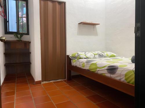 niewielka sypialnia z łóżkiem i oknem w obiekcie Hospedaje Campestre Villa Niny w mieście San Gil