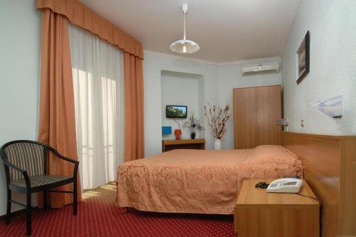 サンレモにあるHotel Sorrisoのベッド1台、電話(テーブル上)が備わる客室です。