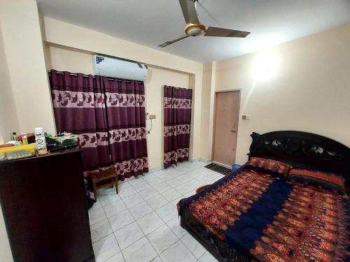 a bedroom with a bed and a ceiling fan at private apartment in hill view tower in Sylhet