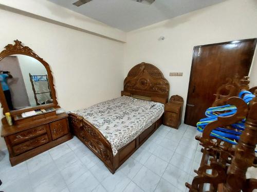 a bedroom with a bed and a dresser and a mirror at private apartment in hill view tower in Sylhet