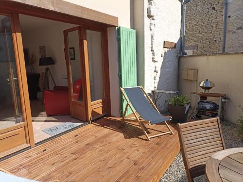 una terraza con una silla y una mesa en Gîte de la cour, en Arçais