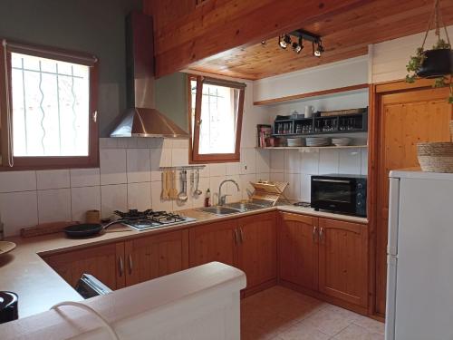 cocina con armarios de madera y horno con fogones en Gîte de la cour, en Arçais