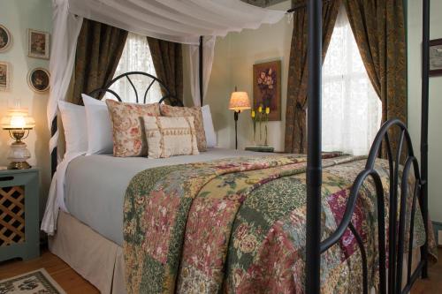 1 dormitorio con 1 cama con dosel en 1825 Inn Bed and Breakfast, en Palmyra