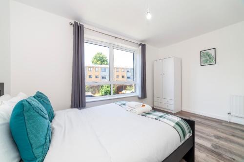 a bedroom with a white bed and a window at Bright 2 BDR house wgarden & parking, Greenwich in London