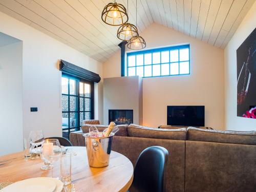 een kamer met een tafel met stoelen en een bank bij Welldone Resort / Cozy Wine in Nieuwerkerken