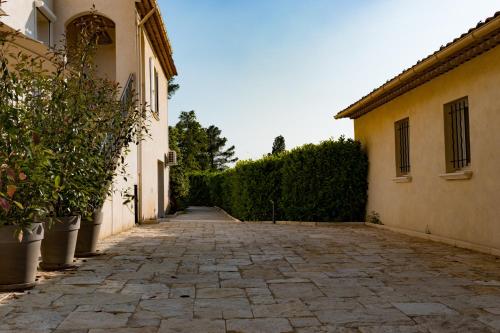 eine Gasse zwischen zwei Gebäuden mit Pflanzen auf beiden Seiten in der Unterkunft Appartement Villa d'Aurore in Le Rouret