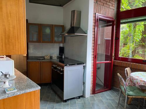 a kitchen with a white refrigerator and a red door at Villa Rama in Aci Castello