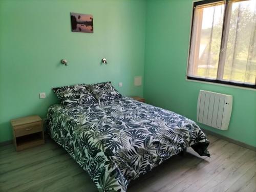 une chambre avec un lit avec une couverture noire et blanche dans l'établissement Bienvenue dans la maison du Ch’ti du Périgord noir, à Audrix