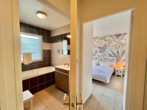 La salle de bains est pourvue d'une baignoire, d'un lit et d'un lavabo. dans l'établissement D34 La Ferme de Deauville 1 ch 1er étage SOZEN, à Saint-Arnoult