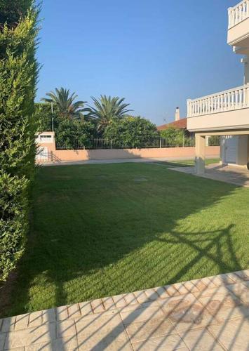 a large yard of green grass next to a house at Villa Zose' luz in Káto Ássos