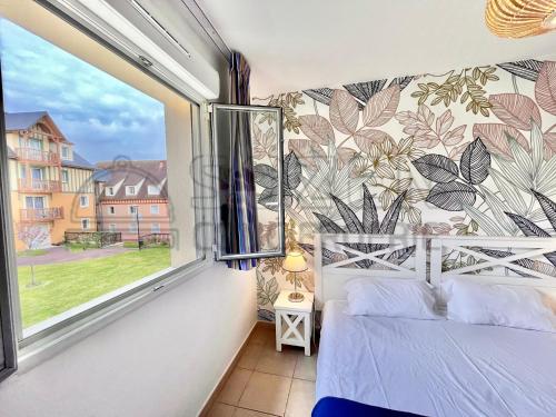 une chambre avec un lit et une grande fenêtre dans l'établissement D34 La Ferme de Deauville 1 ch 1er étage SOZEN, à Saint-Arnoult