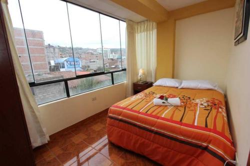 um quarto com uma cama e uma grande janela em Appartments in Cusco em Cusco