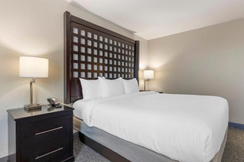 a bedroom with a large white bed and a telephone at Comfort Inn Plano-Dallas in Plano
