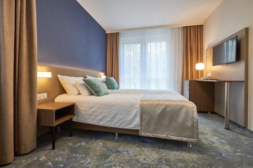 um quarto de hotel com uma cama e uma televisão em Hotel Crystal em Hajdúszoboszló