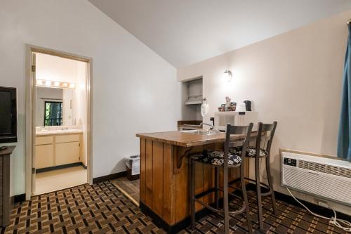 a kitchen with a counter and chairs in a room at Northern Queen Inn in Nevada City