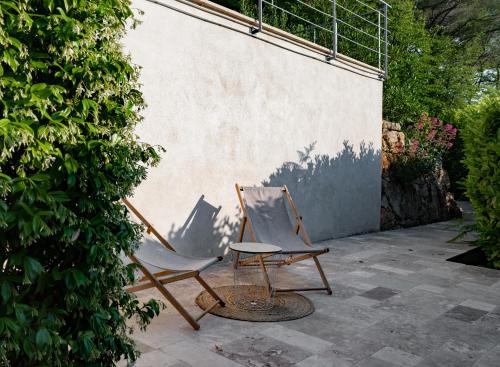 2 sillas y una mesa en el patio en Appartement Villa d'Aurore, en Le Rouret