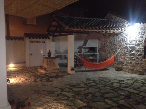 a stone building with a hammock in front of it at Traditional house Zia Dina in Mògoro
