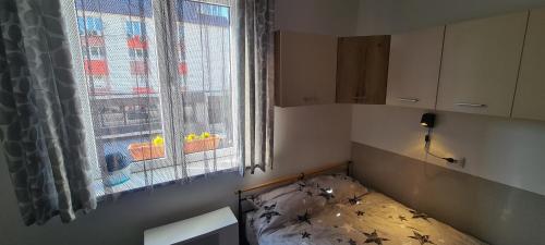 um pequeno quarto com uma cama em frente a uma janela em Little Star Studio em Târgu-Mureş