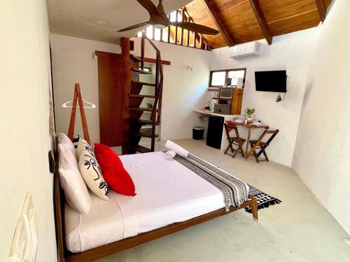 - une chambre avec un lit et des oreillers rouges dans l'établissement Bungalow Unico En Holbox Con Alberca Privada, En Una Propiedad Que Solo Tiene 3 unidades. B1, à Holbox