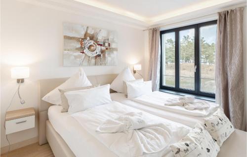 two white beds in a room with a window at Diamond in Binz