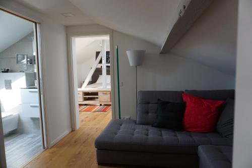 a living room with a couch and a mirror at KeschtaLoft - Gîte classé 4 étoiles in Châtenois