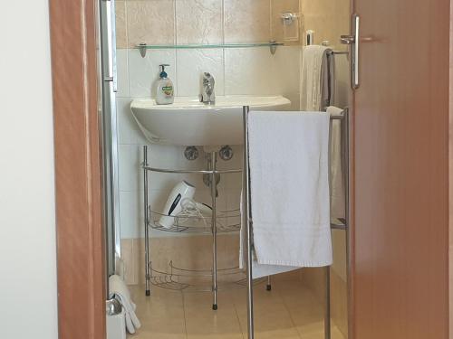 a bathroom with a sink and a white towel at Le Casette in Santa Flavia