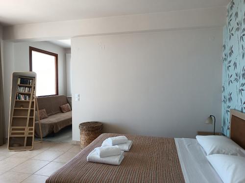 - une chambre avec un lit et des serviettes dans l'établissement Rockgarden Maisonette, à Káto Váthia
