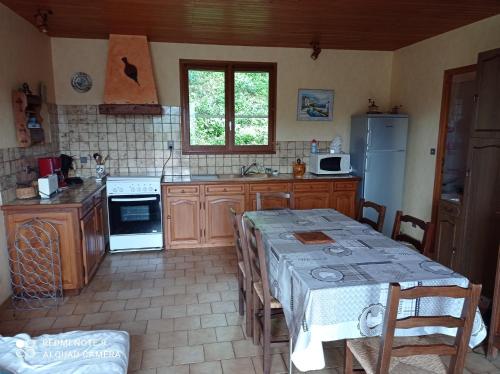 une cuisine avec des armoires en bois et une table avec des chaises dans l'établissement Gite l Ostal de Lulu, à Saint-André