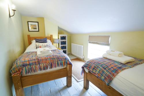 オールドバラにあるAldeburgh Cottageのベッドルーム1室(ベッド2台、タオル付)