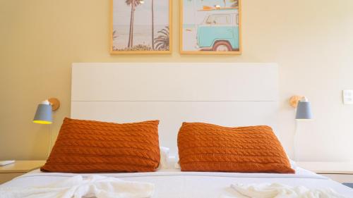 a bedroom with a bed with two orange pillows at Residencial Las Salinas in Maresias