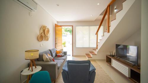 a living room with a couch and a television at Residencial Las Salinas in Maresias