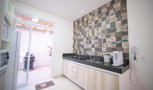 a kitchen with a sink and a tile wall at Residencial Las Salinas in Maresias