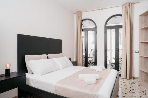 a bedroom with a large white bed with two towels on it at Vista Napoli Residence - Il Cortile in Naples