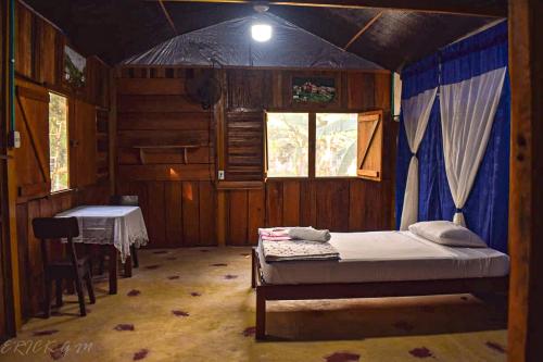 Hostal Caño Nevera في La Macarena: غرفة نوم فيها سرير وطاولة فيها