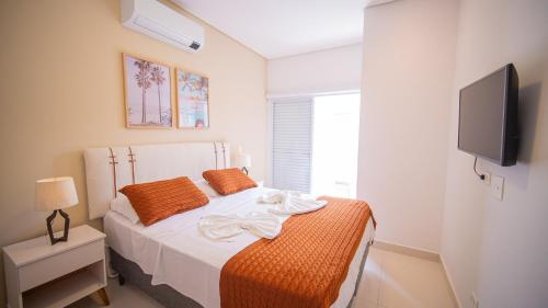 a bedroom with a bed and a tv on a wall at Residencial Las Salinas in Maresias