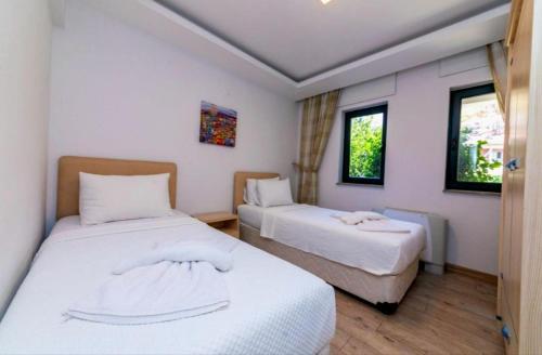 a room with two beds and two windows at House Sapphire in Marmaris