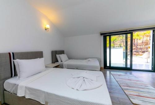 a bedroom with two beds and a large window at House Sapphire in Marmaris
