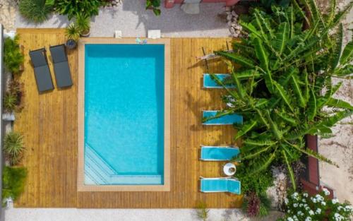 una vista aérea de una piscina con sillas azules en Happy Curoase, en Willemstad