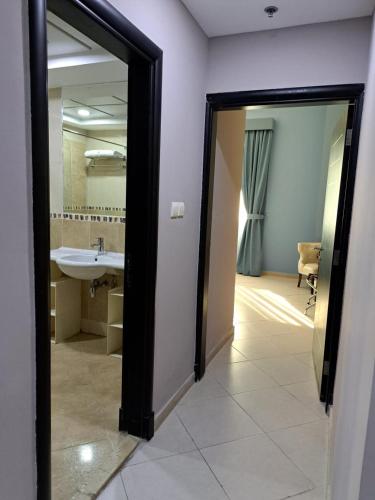 VVIP Apartment في دبي: حمام مع حوض ومرآة