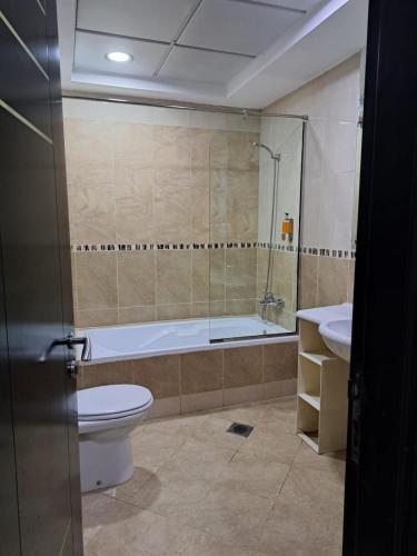 VVIP Apartment في دبي: حمام مع مرحاض وحوض استحمام ومغسلة