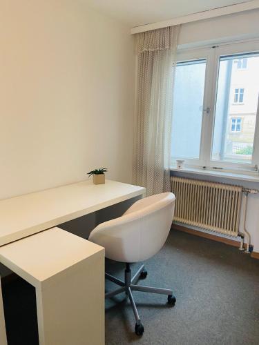 a office with a white desk and a white chair at Zentrale Wohnung Gmunden Alte Bäckerei in Gmunden