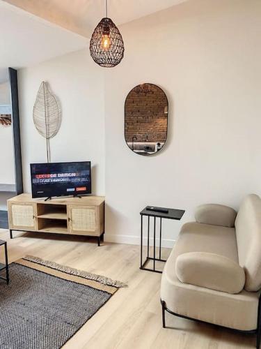 uma sala de estar com um sofá e uma televisão em Le Pantaléon - Sublime Studio Capitole em Toulouse