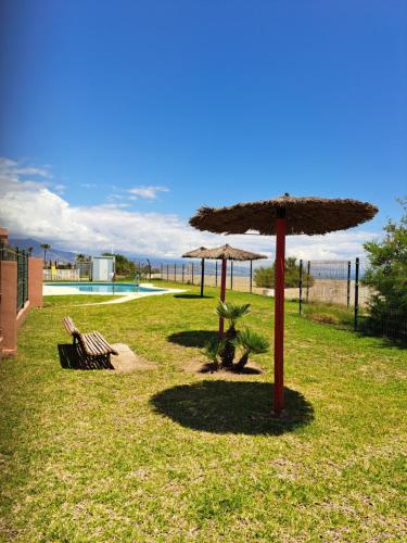 a patio with a umbrella and chairs and a pool at Manilva Beach 97 in Manilva