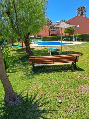 a park bench with an umbrella next to a pool at Manilva Beach 97 in Manilva