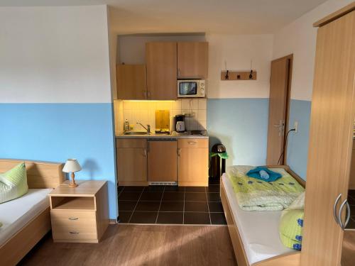 a small room with a bed and a kitchen at Ferienwohnungen Hennig in Heringsdorf