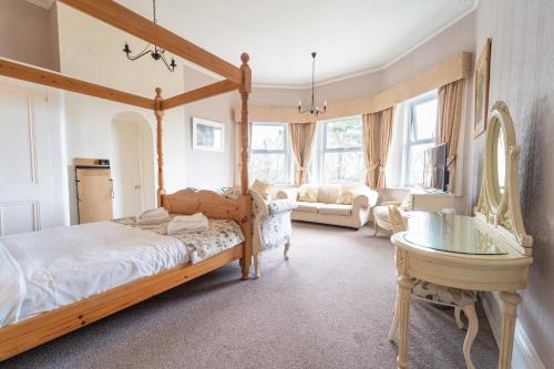 ein Schlafzimmer mit einem Himmelbett und ein Wohnzimmer in der Unterkunft Bourne Hall Country Hotel in Shanklin