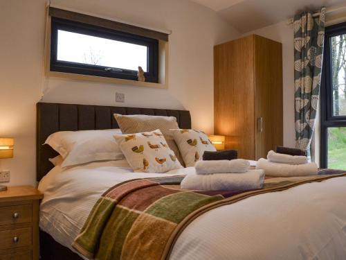 a bedroom with a large white bed with a window at Osprey Lodge in Westward