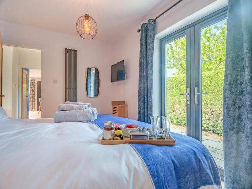a bedroom with a bed with a tray of food on it at Araglin in Worstead